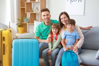 Evde bavulları olan mutlu bir aile.