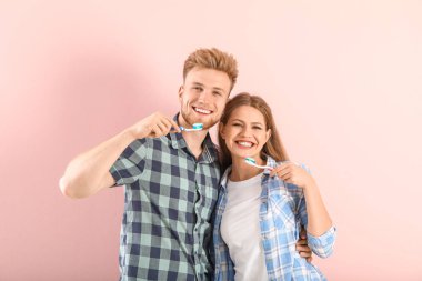 Arka planda dişlerini fırçalayan genç çift