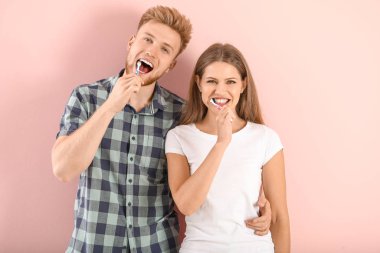 Arka planda dişlerini fırçalayan genç çift