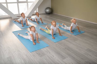 Küçük çocuklar spor salonunda Yoga uygulamak