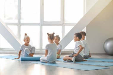 Küçük çocuklar spor salonunda Yoga uygulamak