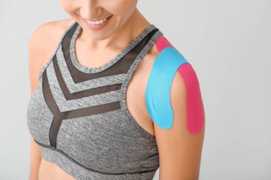 Omzuna hafif arka plan bandı yapıştırılmış spor kadın, yakın plan.