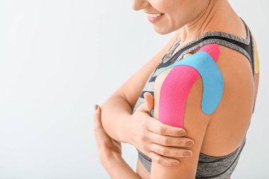 Omzuna hafif arka plan bandı yapıştırılmış spor kadın, yakın plan.
