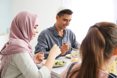 Müslüman bir aile evde yemek yiyor.