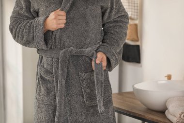 Bornozlu yakışıklı genç, yakın plan.