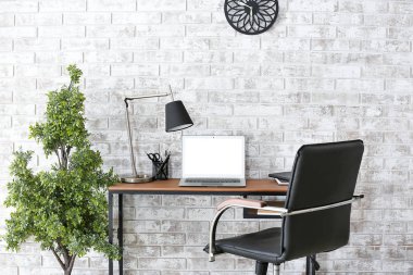 Modern odada dizüstü bilgisayarı olan şık ve rahat bir iş yeri.