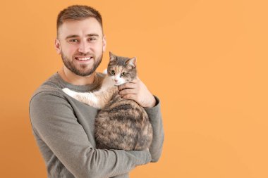 Renkli arka planda sevimli kedisi olan adam