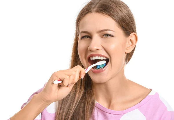Νεαρή γυναίκα βουρτσίζει τα δόντια σε λευκό φόντο — Φωτογραφία Αρχείου