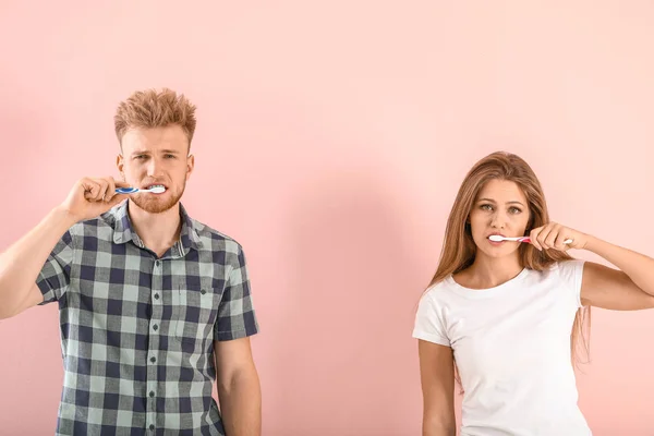 年轻夫妇用彩色底色刷牙 — 图库照片