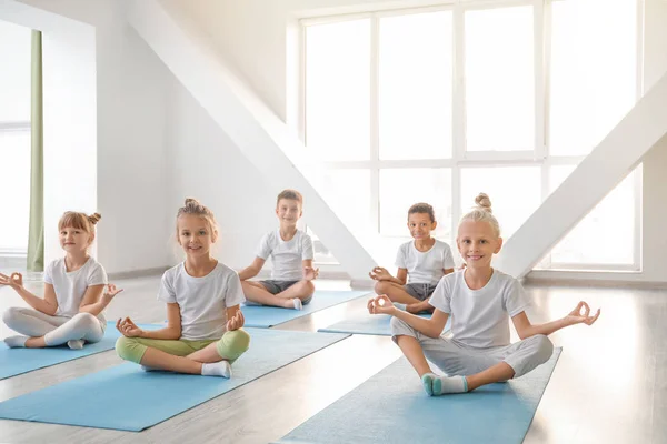 Niños pequeños practicando yoga en el gimnasio — Foto de Stock