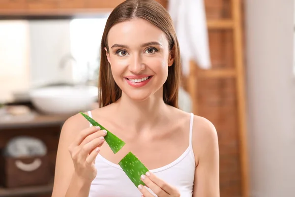 Beautiful young woman with aloe vera in bathroom — Stock Photo, Image