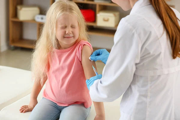 Doktorka, co očiuje malou holčičku na klinice — Stock fotografie