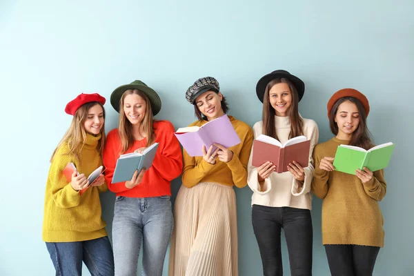 Mladé ženy s knihami na barevném pozadí — Stock fotografie