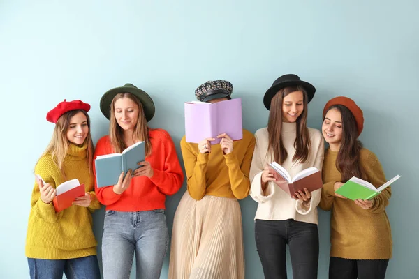 Renkli arka plan kitapları olan genç kadınlar