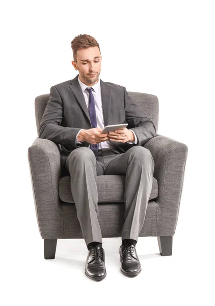 Hombre de negocios guapo con Tablet PC sentado en sillón sobre fondo blanco — Foto de Stock