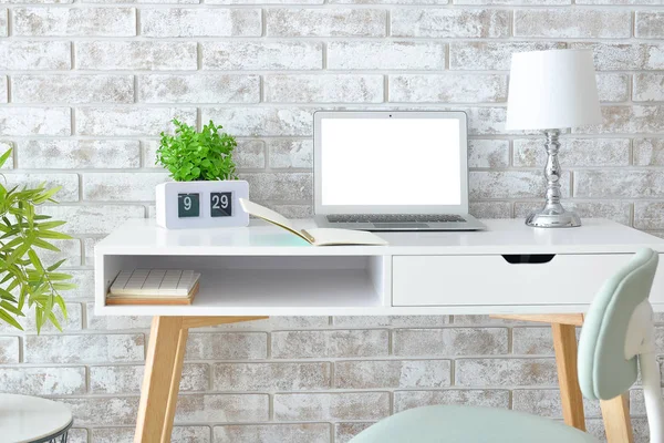 Modern odada dizüstü bilgisayarı olan şık ve rahat bir iş yeri.