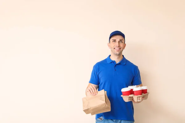 Trabalhador bonito do serviço de entrega de alimentos no fundo de cor — Fotografia de Stock
