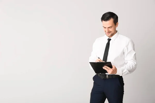 Male real estate agent on light background — Stock Photo, Image