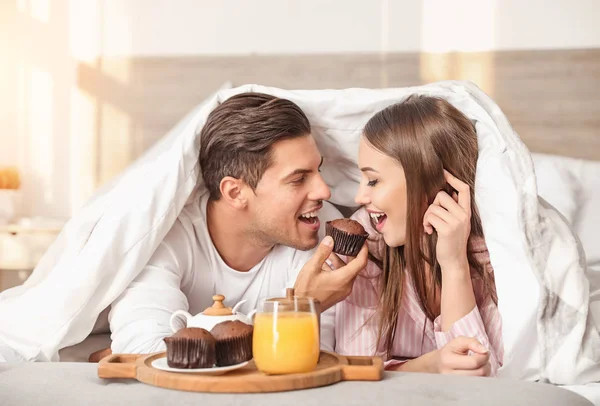 Manhã do jovem casal tomando café da manhã na cama — Fotografia de Stock