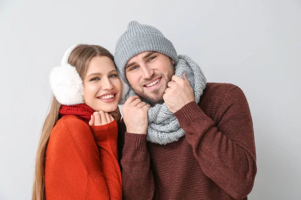 Retrato de pareja feliz en ropa de invierno sobre fondo claro — Foto de Stock