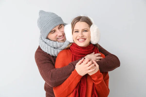 Retrato de pareja feliz en ropa de invierno sobre fondo claro — Foto de Stock