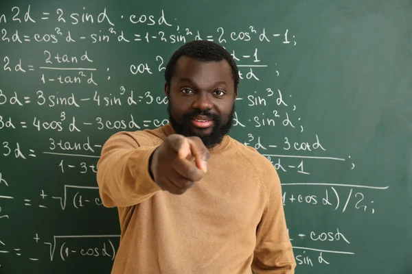 Professor de matemática afro-americano perto de quadro negro em sala de aula — Fotografia de Stock