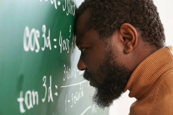 Profesor de matemáticas afroamericano desesperado cerca de la pizarra — Foto de Stock