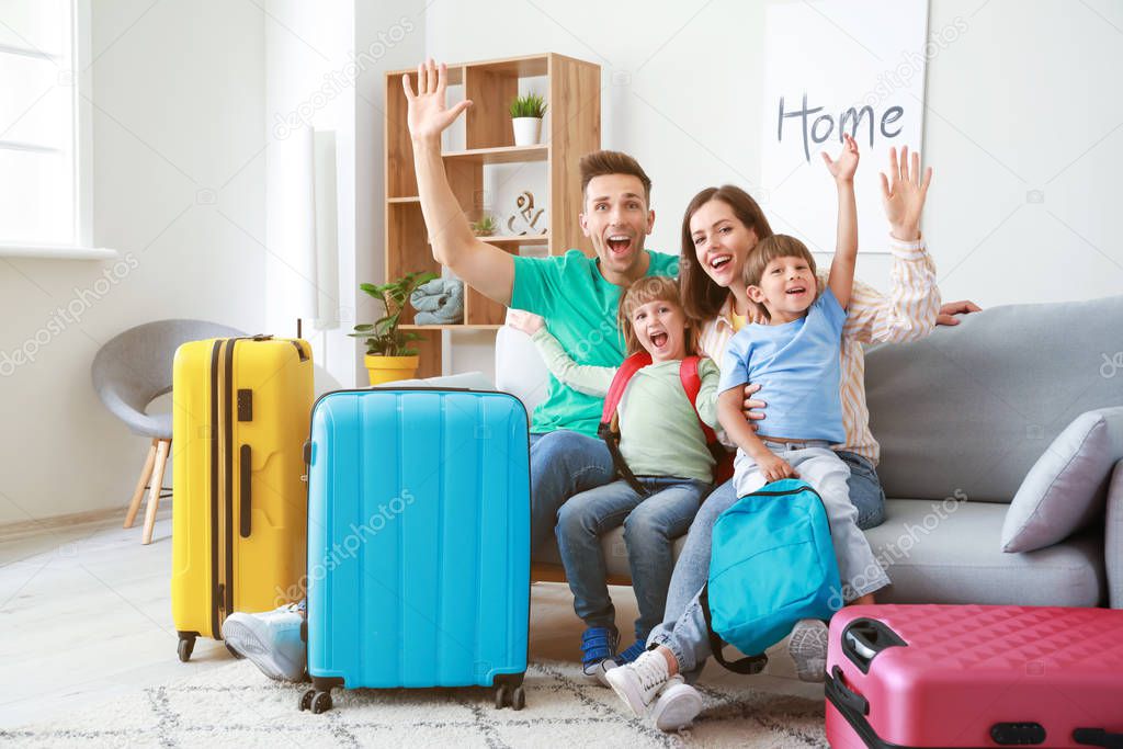 Happy family with packed suitcases at home