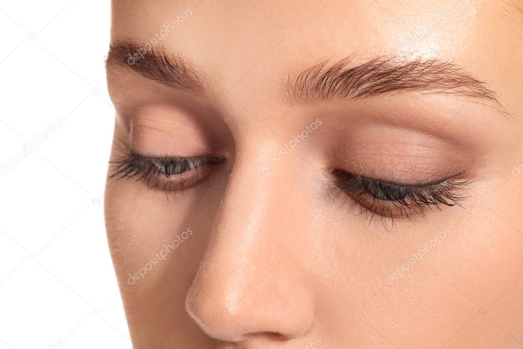 Young woman with beautiful eyebrows on white background, closeup