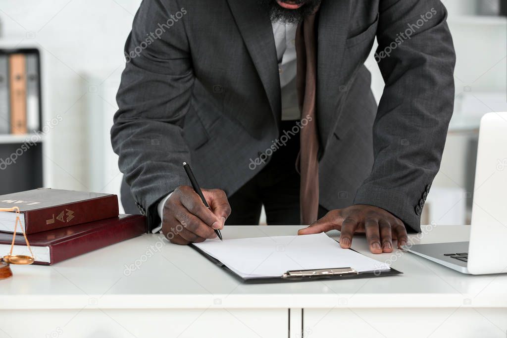 Lawyer signing documents in office
