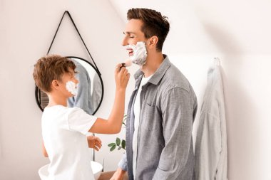 Baba oğul banyoda yüzlerine tıraş köpüğü sürüyorlar.