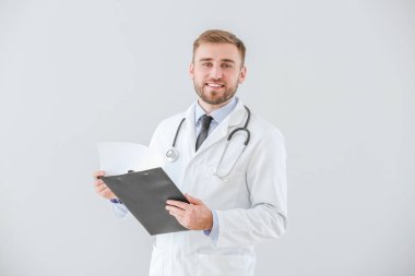 Açık arkaplanda panosu olan erkek doktorun portresi
