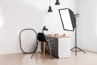 Modern fotoğraf stüdyosunun içinde profesyonel ekipman ve yemek masasında.