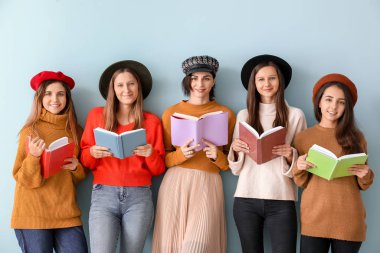 Renkli arka plan kitapları olan genç kadınlar