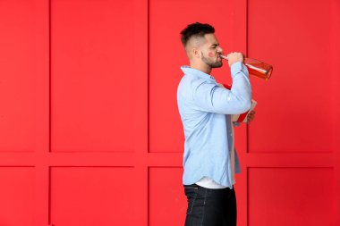 Arkaplanda hediye ve şampanya olan sarhoş adam.