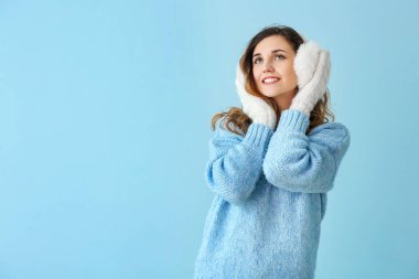 Kalın süveter ve renkli eldiven giymiş güzel bir kadın.