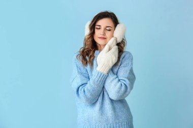 Kalın süveter ve renkli eldiven giymiş güzel bir kadın.