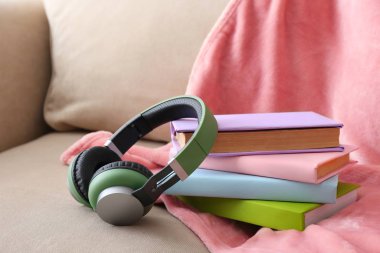 Kitaplar ve modern kulaklıklar koltukta. Ses kitapçığı kavramı