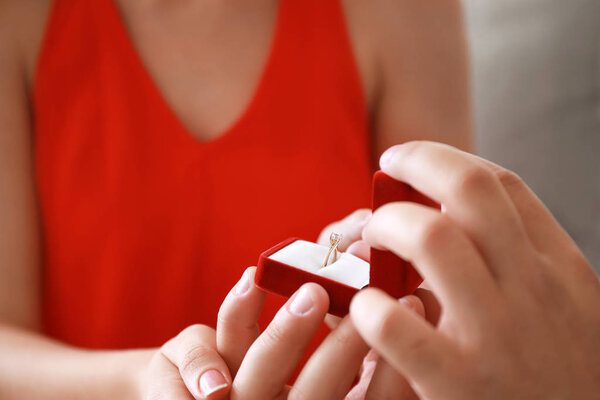 Молодой человек делает предложение своей возлюбленной дома, крупным планом
