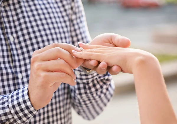 Νεαρός άνδρας, βάζοντας το δαχτυλίδι στο δάχτυλό της μνηστής μετά την πρόταση γάμου, κοντινό πλάνο — Φωτογραφία Αρχείου
