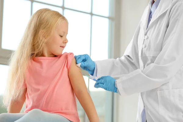 クリニックで小さな女の子にワクチンを接種する医師 — ストック写真