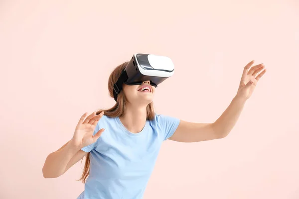 Young woman with virtual reality glasses on color background — Stock Photo, Image