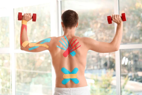 Sporty man with physio tape training in gym — Stock Photo, Image