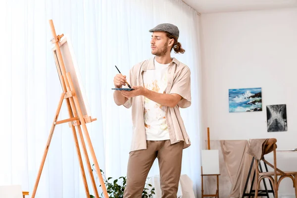 Young male artist working in studio