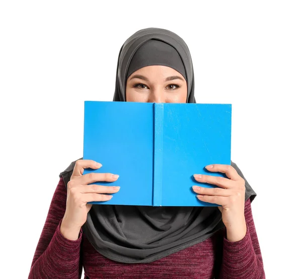 Portrait of young Muslim woman with book on white background — Stock Photo, Image