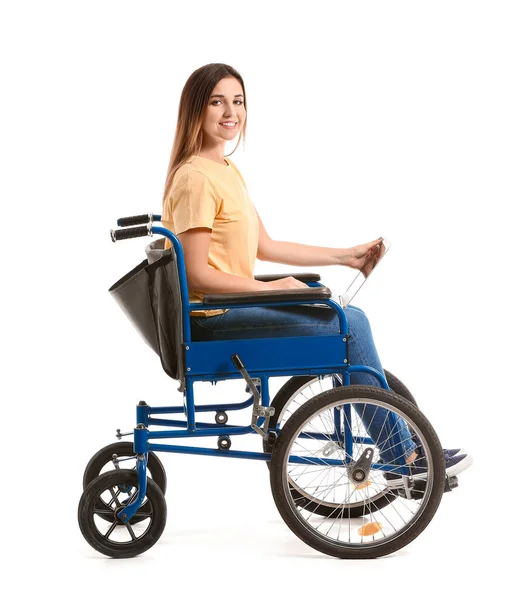 Young woman in wheelchair and with laptop on white background — Stock Photo, Image