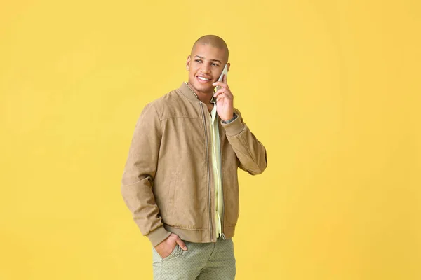 Stylish African-American man talking by mobile phone on color background — 스톡 사진
