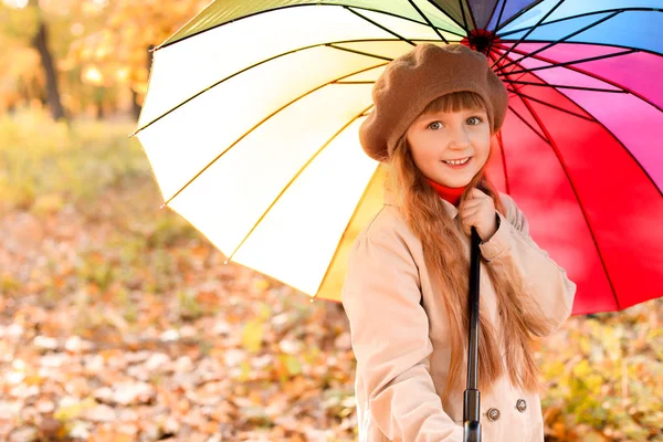 Cute little girl with umbrella in autumn park — Stock Photo, Image