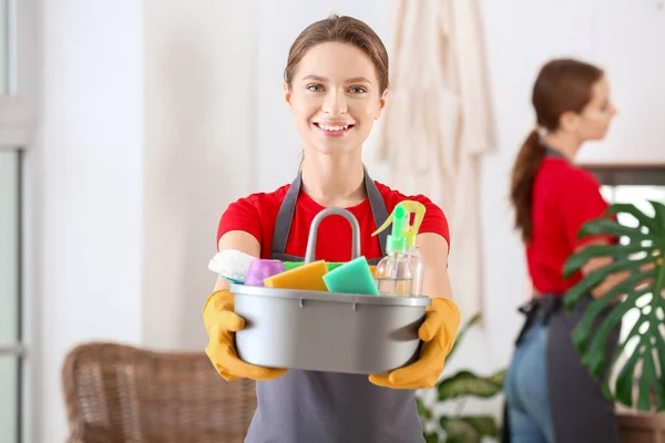 Conciërge met schoonmaakmiddelen in badkamer — Stockfoto