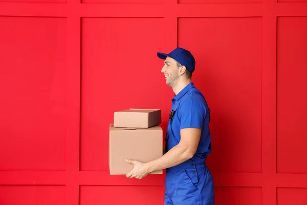 Entrega hombre con cajas en el fondo de color —  Fotos de Stock